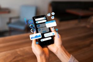 Home 2 Pessoa utilizando um smartphone com interface digital flutuante, representando as facilidades oferecidas pelos bancos digitais e superapps para gerenciar finanças, reduzir tarifas e economizar no dia a dia.